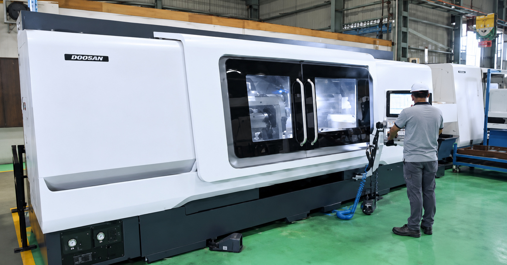 An operator at a long Doosan CNC machine
