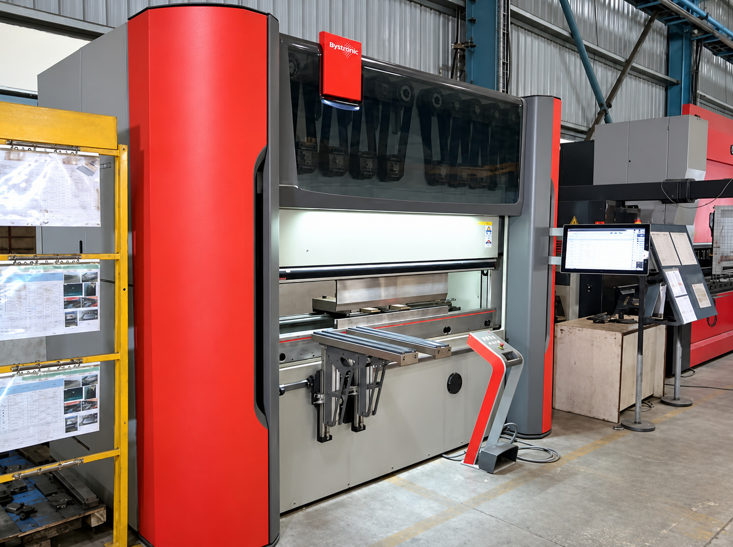 A red and grey Bystronic CNC press brake with its control screen